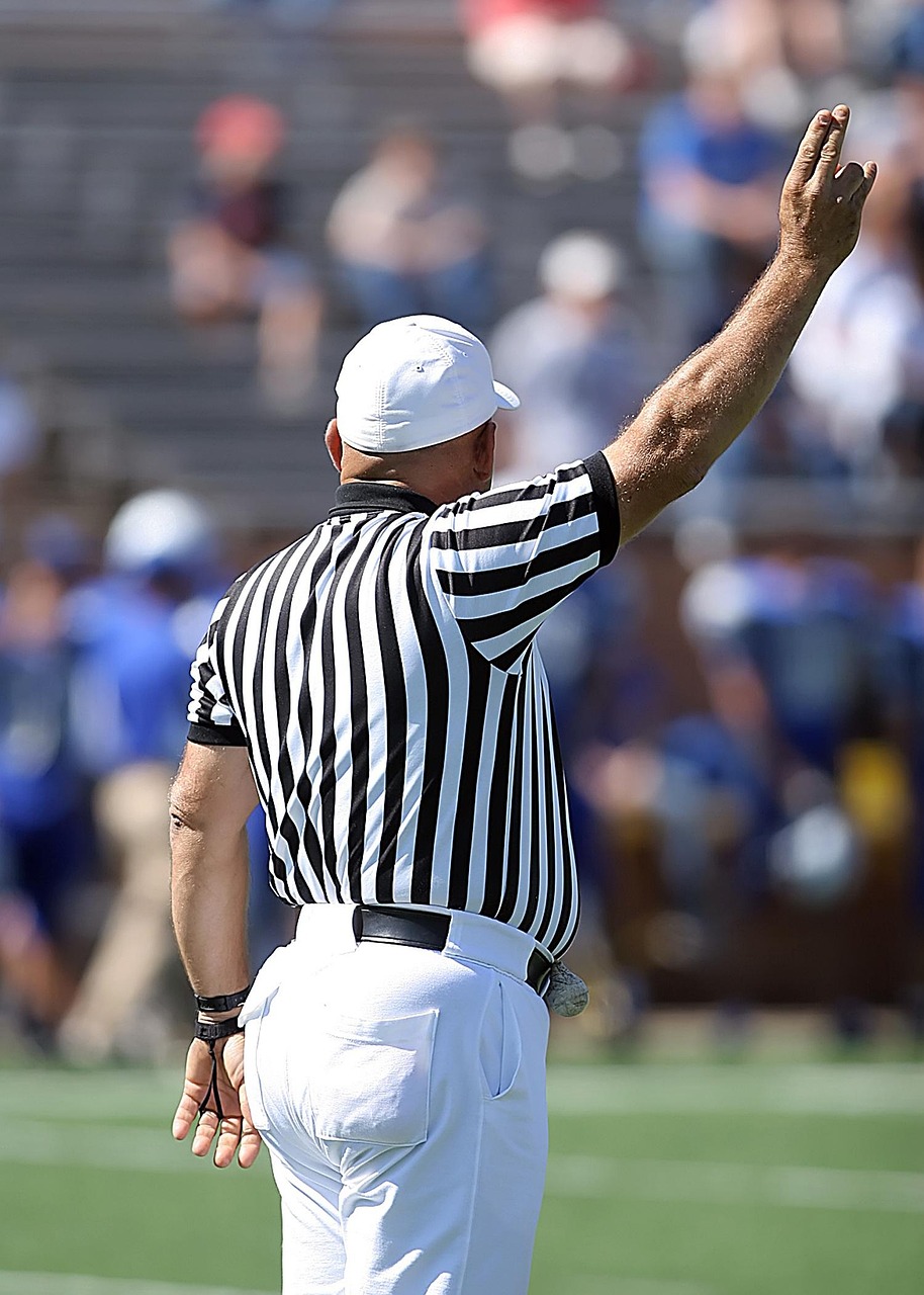Arbitre qui fait un signe de main sur un terrain de football